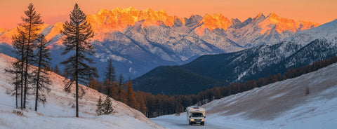 RV solar kit with a camper in snowy mountains at sunset, ideal for off-grid energy on outdoor adventures.